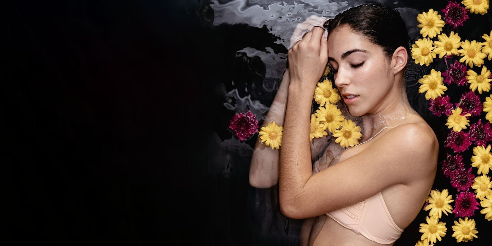 Femme apaisée entourée de fleurs, illustrant la sensorialité des soins naturels certifiés COSMOS NATURAL ou ORGANIC – KALYAË ORIGIN