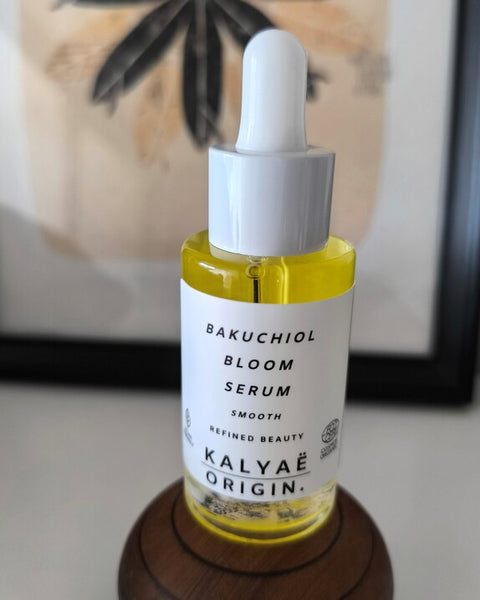 Bakuchiol Bloom Serum anti-âge lissant certifié COSMOS ORGANIC 30 ml présenté en avis client sur support en bois décoratif – KALYAË ORIGIN