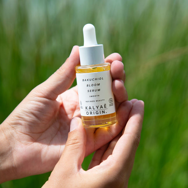 Bakuchiol Bloom Serum anti-âge lissant certifié COSMOS ORGANIC 30 ml présenté en application en extérieur – KALYAË ORIGIN