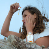 Berry Repair Oil huile régénérante visage certifiée COSMOS ORGANIC 30 ml présentée en application en extérieur dans un décor naturel – KALYAË ORIGIN