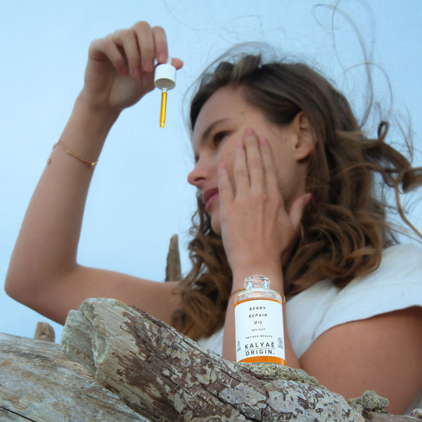 Berry Repair Oil huile régénérante visage certifiée COSMOS ORGANIC 30 ml présentée en application en extérieur dans un décor naturel – KALYAË ORIGIN