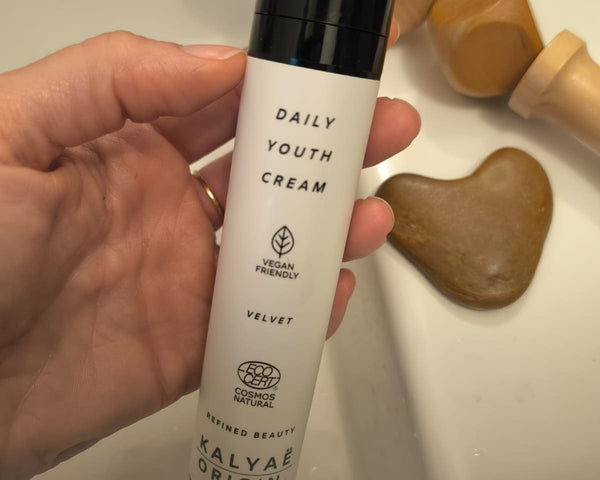 Daily Youth Cream crème visage certifiée COSMOS NATURAL 50 ml présentée en application près d’un lavabo – KALYAË ORIGIN