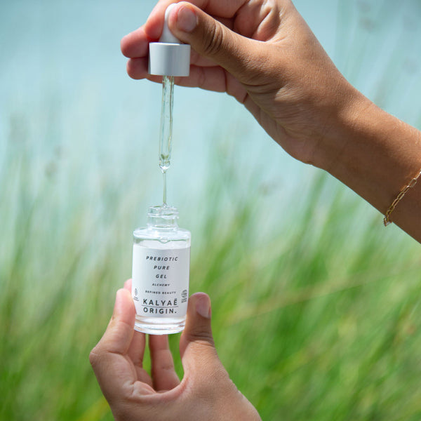 Prebiotic Pure Gel hydratant et équilibrant aux prébiotiques certifié COSMOS NATURAL 30 ml présenté en application sur fond de nature – KALYAË ORIGIN