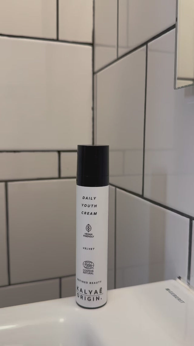 Vidéo de présentation de la Daily Youth Cream crème signature visage certifiée COSMOS NATURAL 30 ml montrée sur une étagère de salle de bain avec miroir – KALYAË ORIGIN