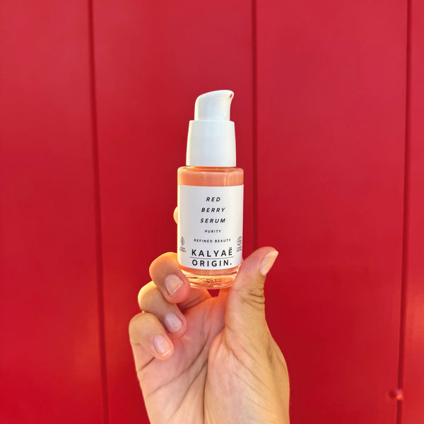 Red Berry Serum peau sensible certifié COSMOS NATURAL 30 ml présenté en main sur fond rouge – KALYAË ORIGIN